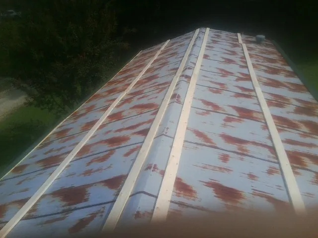 Rusted metal roof panels with new wood purlins before replacement — Storm Damage Roof Repair in Keene Valley by Roofing Brothers