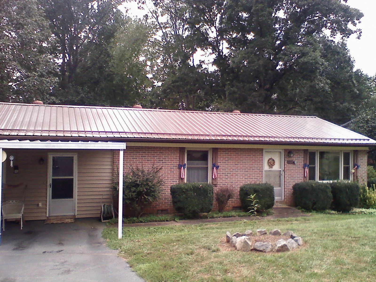 Bronze metal roof and carport on a brick ranch home — Roof Repair work by our crew in Keene Valley